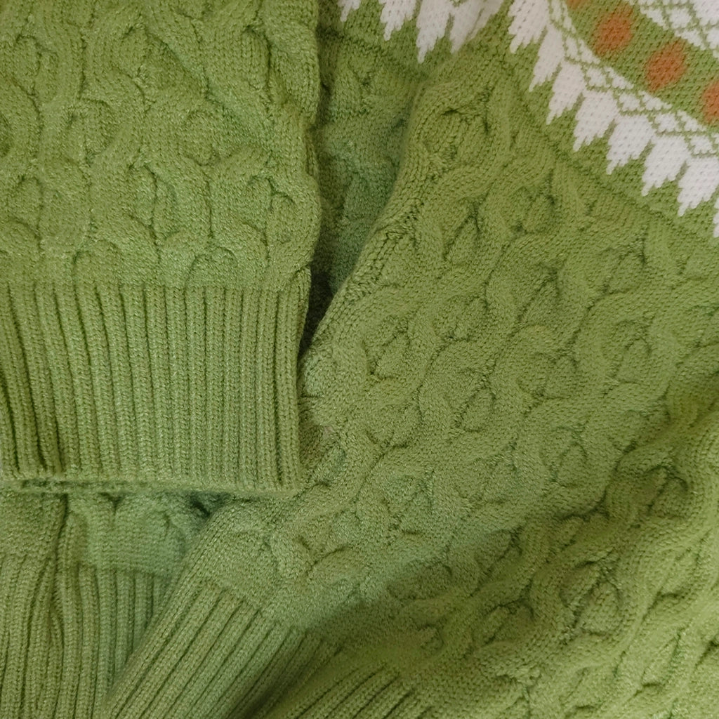 Close-up of a green knitted sweater with cable pattern