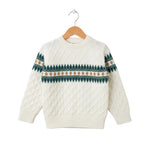 White sweater with green and brown pattern on a wooden hanger against a white background