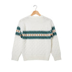 White sweater with green and brown pattern on a hanger against a white background
