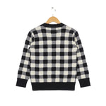 Black and white checkered sweater on a hanger against a white background