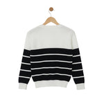 Black and white striped sweater on a wooden hanger against a light gray background