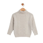 Beige cable knit sweater on a wooden hanger against a white background