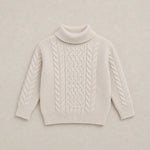 Beige cable knit sweater on a wooden hanger against a white background
