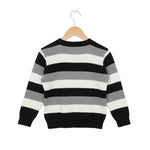 Black, white, and gray striped sweater on a hanger against a white background