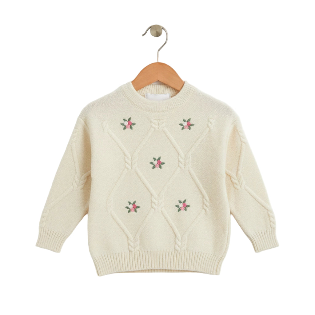 Cream-colored sweater with floral embroidery on a wooden hanger against a white background