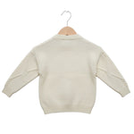Beige sweater on a wooden hanger against a white background