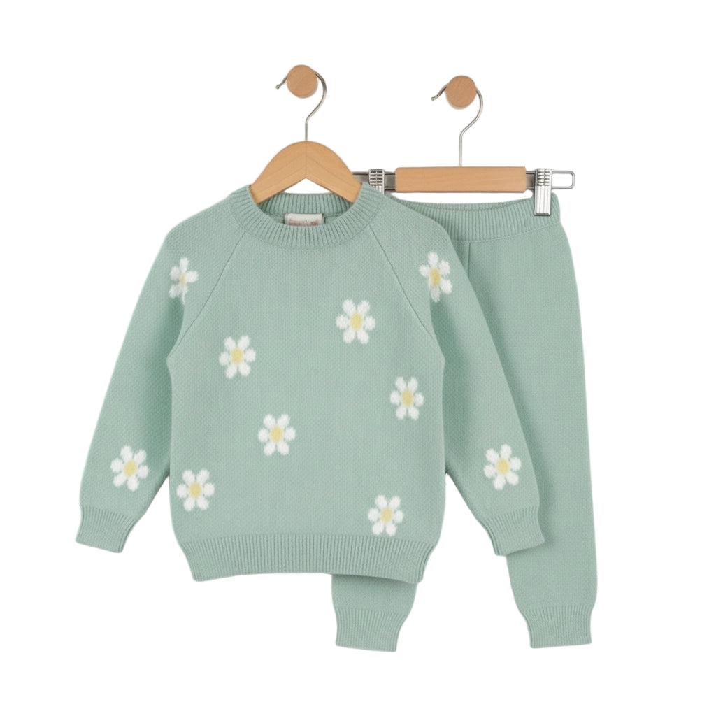Green children's sweater with white daisy patterns on a white background