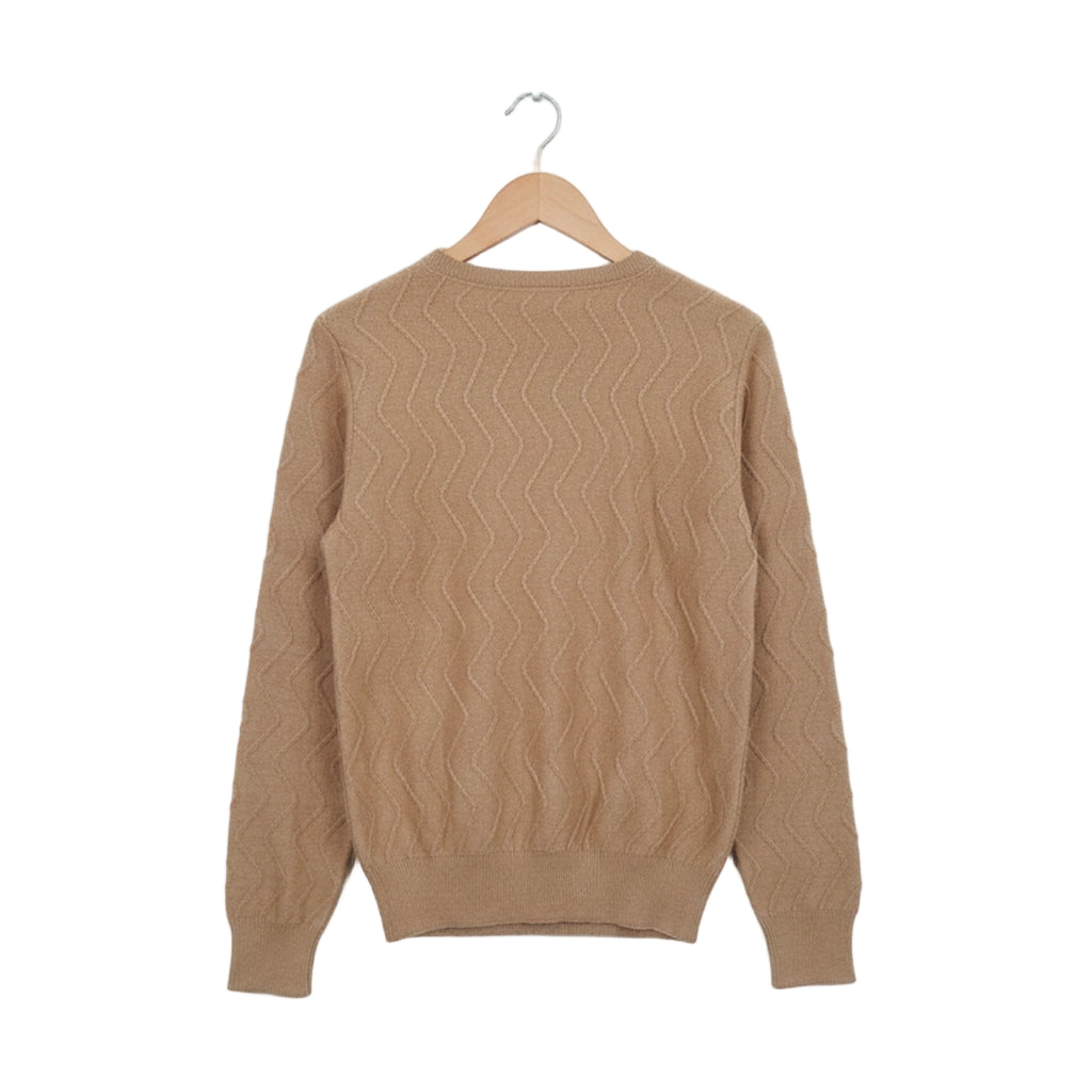 Beige sweater on a wooden hanger against a white background