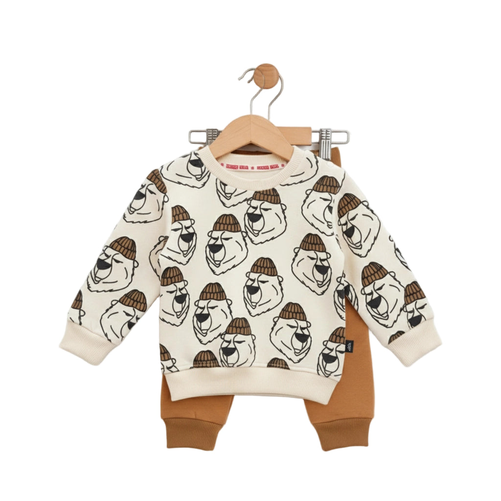 Children's outfit with patterned top and brown pants on a hanger against a white background
