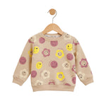 Children's beige sweatshirt with smiley face and flower patterns on a hanger against a white background