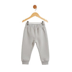 Gray sweatpants on a wooden hanger against a white background
