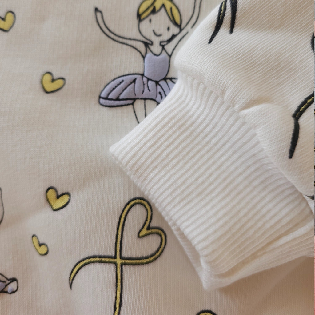 Close-up of a textured fabric with ballerina and heart designs.