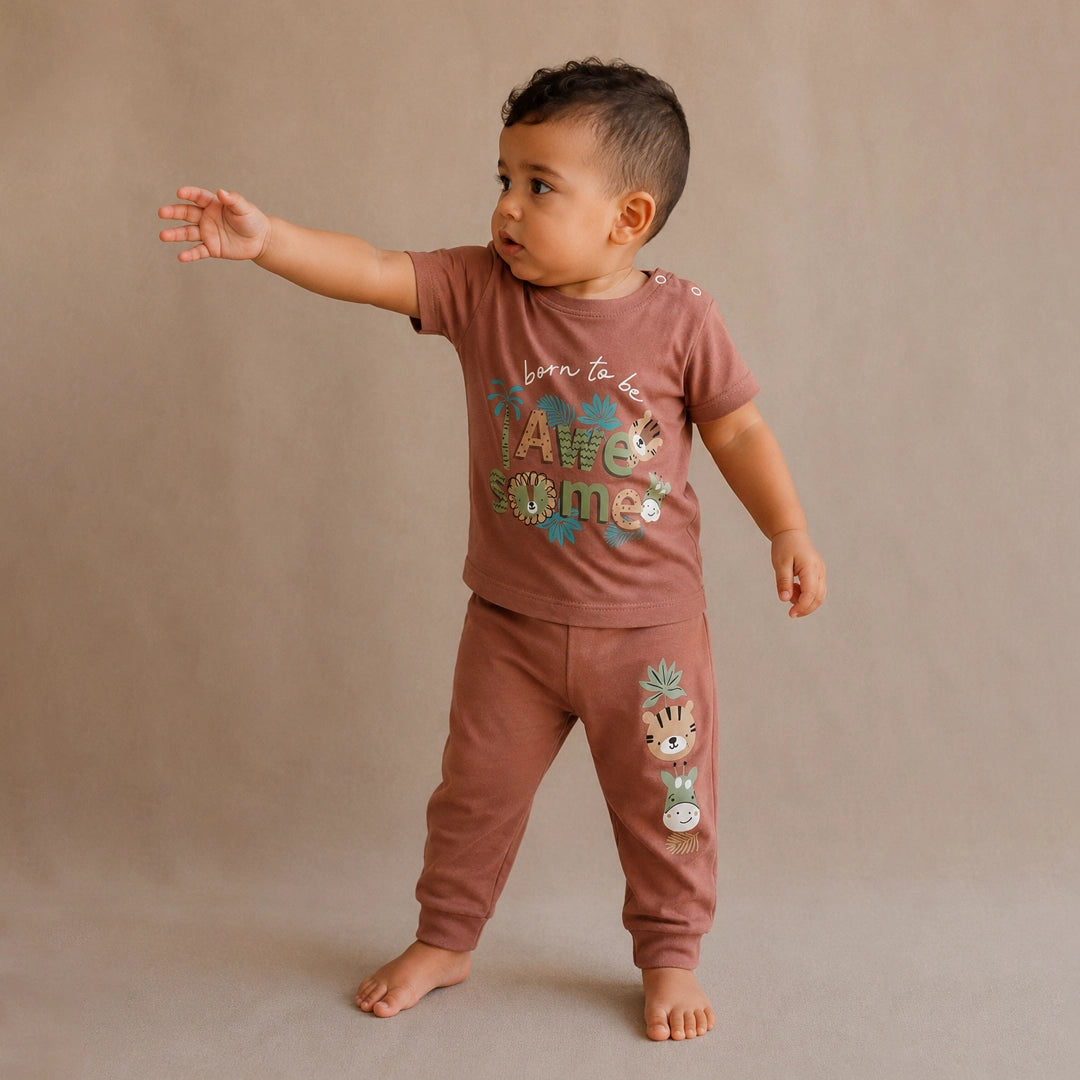 Child wearing a matching shirt and pants set with text and graphics on a beige background