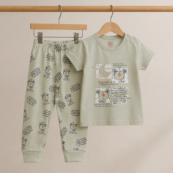 Children's pajama set with teddy bear design on a beige background