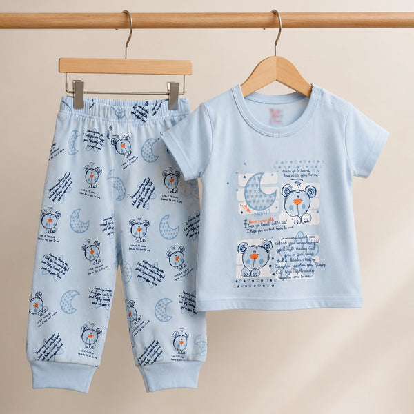 Children's pajama set with teddy bear design on a beige background