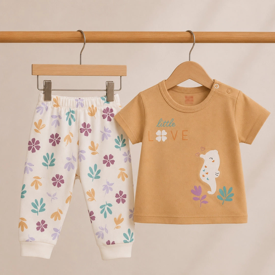 Baby outfit with floral pants and tan shirt with 'Little Love' design on a beige background
