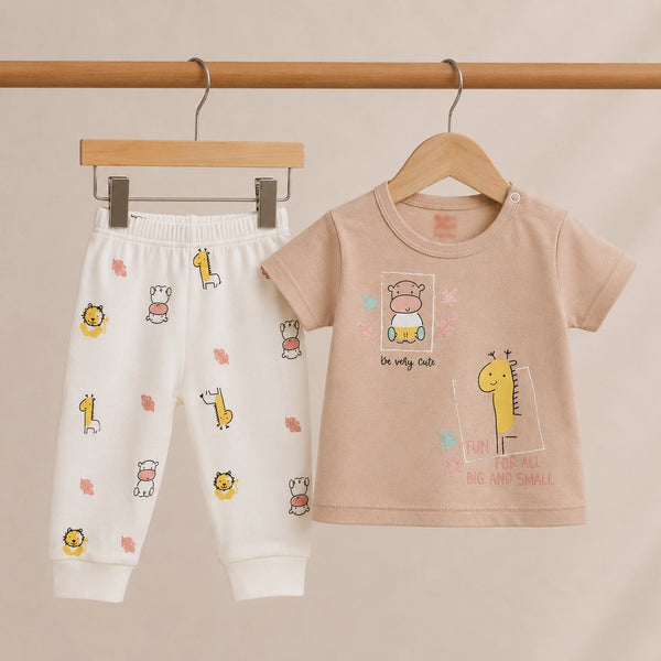 Children's outfit with t-shirt and pants on hangers against a beige background