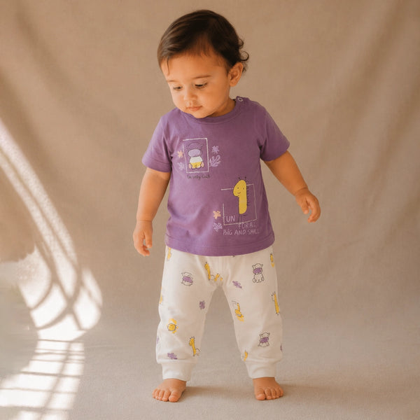 Child wearing a purple shirt and white pants with yellow patterns on a beige background