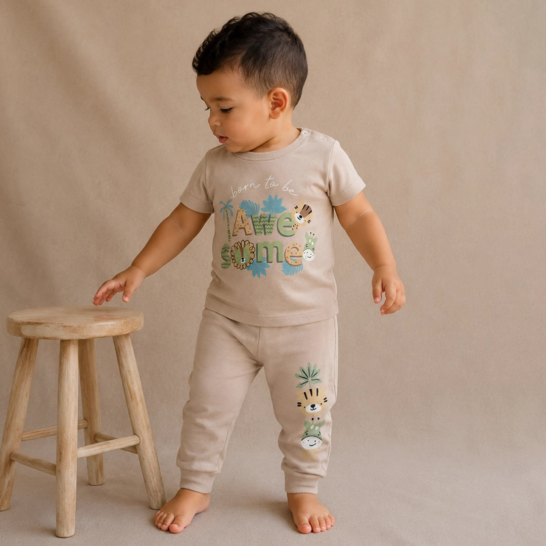 Child wearing a beige outfit with animal prints on a beige background