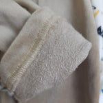 Close-up of beige fabric with visible stitching