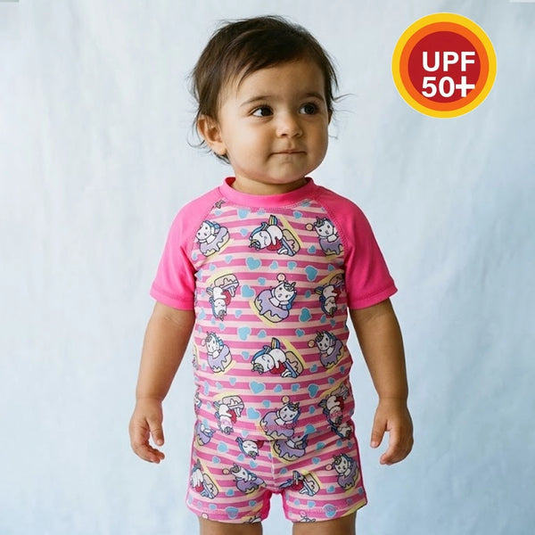Child wearing a pink cartoon-themed swimsuit with UPF 50+ label on a white background