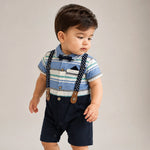 Child wearing a striped shirt, navy shorts, and suspenders on a plain background