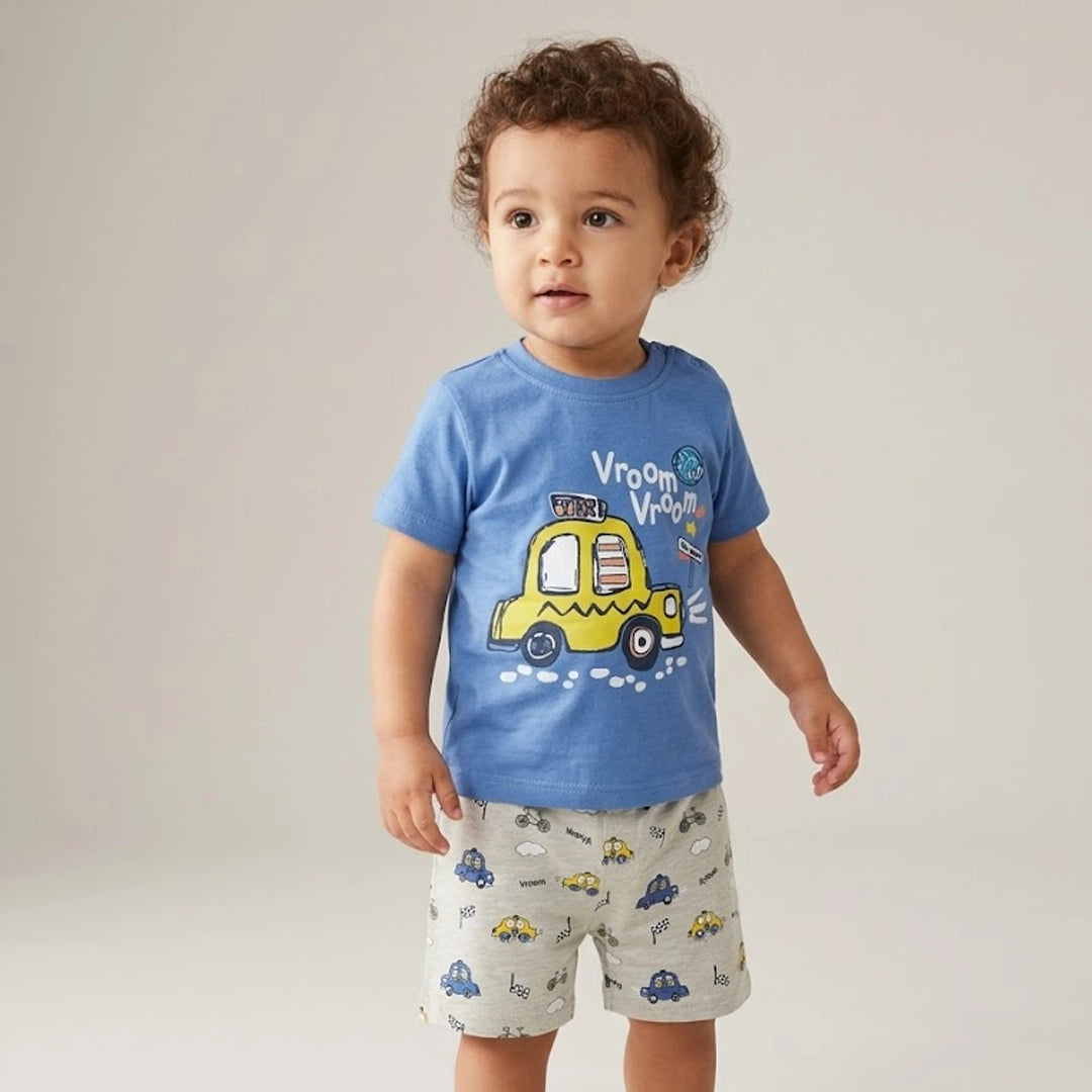 Child wearing a blue t-shirt with a yellow car graphic and gray shorts with car patterns on a plain background