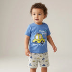 Child wearing a blue t-shirt with a yellow car graphic and gray shorts with car patterns on a plain background