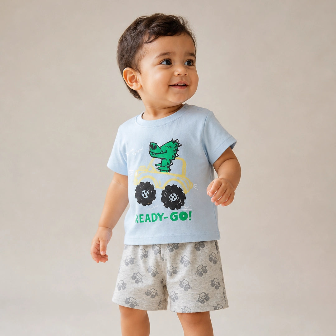 Child wearing a light blue t-shirt with a dinosaur graphic and text, standing against a plain background.