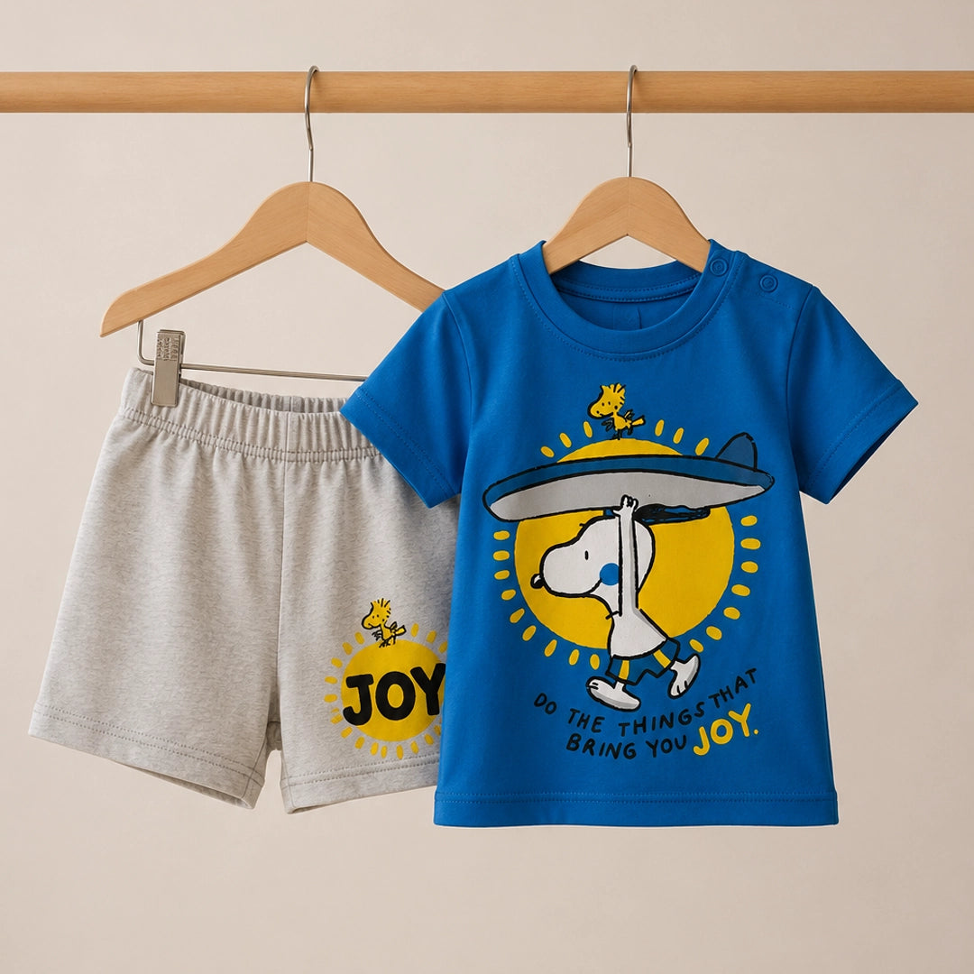 Children's blue t-shirt and gray shorts with a cartoon design and 'JOY' text on a beige background.