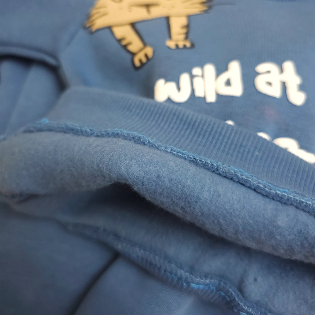 Close-up of a blue fabric with text and a lion design.