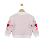 Pink sweater with red and white pattern on sleeves, hanging on a wooden hook against a white background.