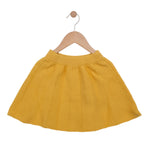 Yellow skirt on a wooden hanger against a white background