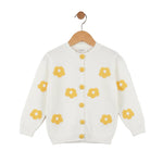 White cardigan with yellow floral patterns on a wooden hanger against a white background