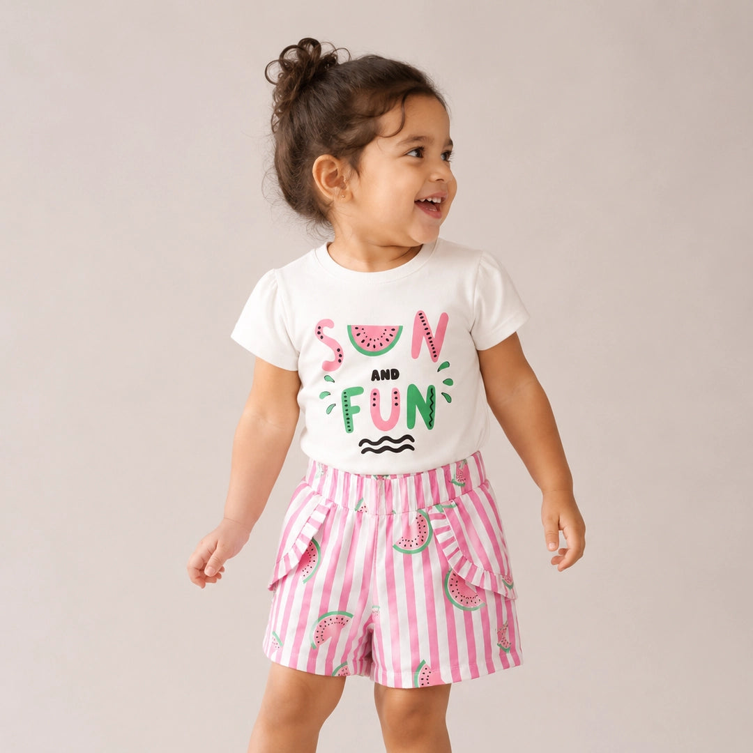 Child wearing a white t-shirt with 'Sun and Fun' text and pink shorts with watermelon pattern on a plain background