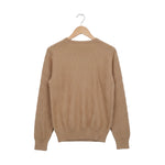 Beige sweater on a wooden hanger against a white background