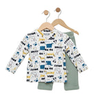 Children's outfit with patterned long-sleeve shirt and green pants on hangers against a white background