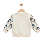 Children's sweater with bear pattern on sleeves hanging on a wooden hanger against a white background