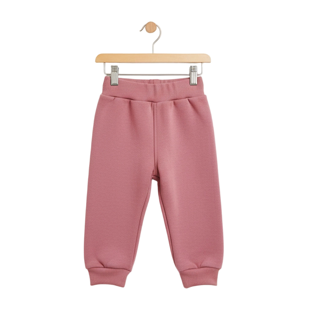 Pink sweatpants on a hanger against a white background