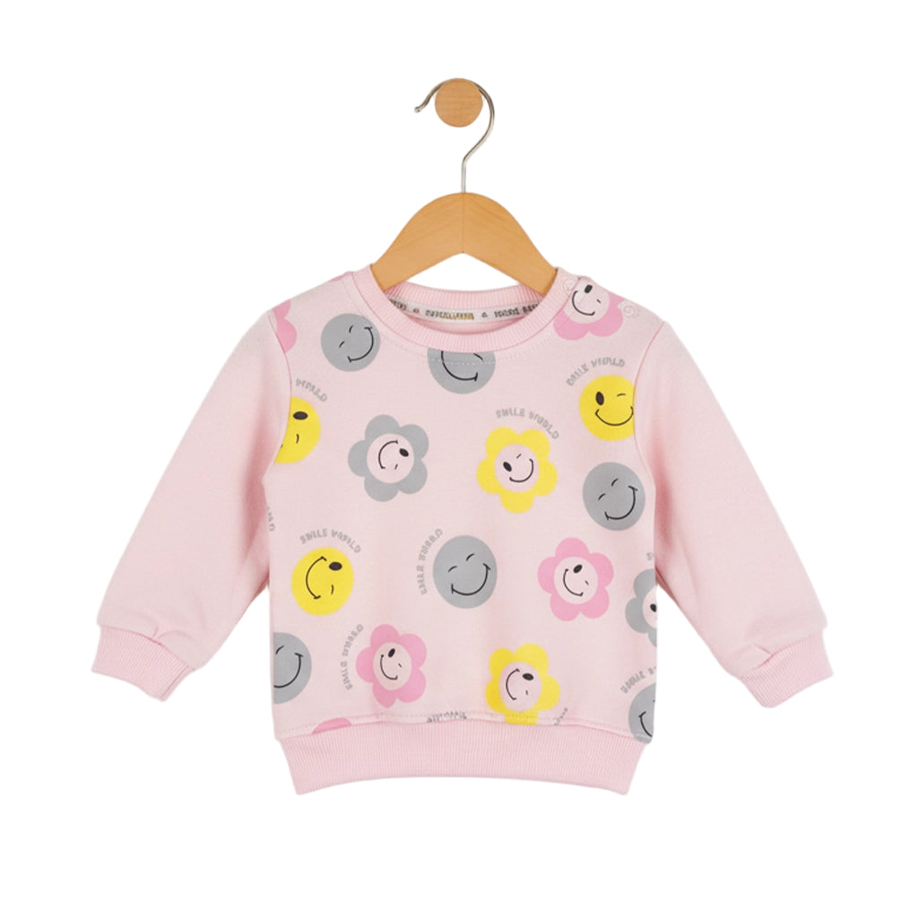Pink children's sweatshirt with smiley face patterns on a hanger against a white background