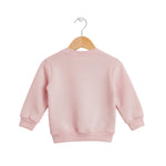 Pink children's sweatshirt on a wooden hanger against a light gray background