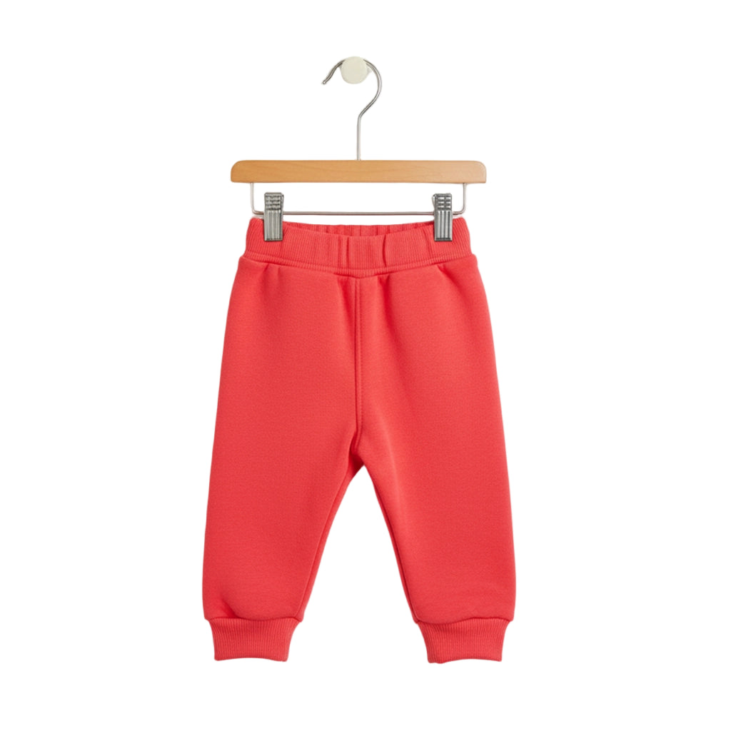Red children's sweatpants on a hanger against a white background