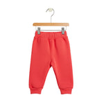Red children's sweatpants on a hanger against a white background