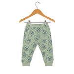 Green children's pants with a pattern on a wooden hanger against a white background