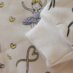 Close-up of a textured fabric with ballerina and heart designs.