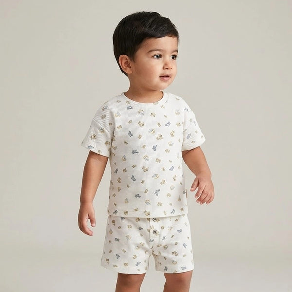 Child wearing a white pajama set with small patterns on a plain background