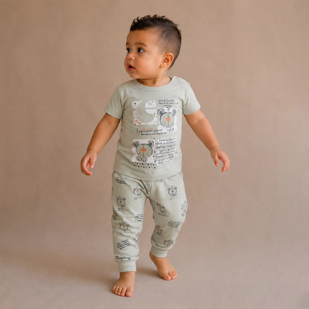 Child wearing a light green pajama set with animal prints on a beige background