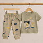 Children's outfit with t-shirt and pants on hangers against a beige background