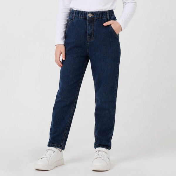 Person wearing blue jeans and white sneakers on a plain background