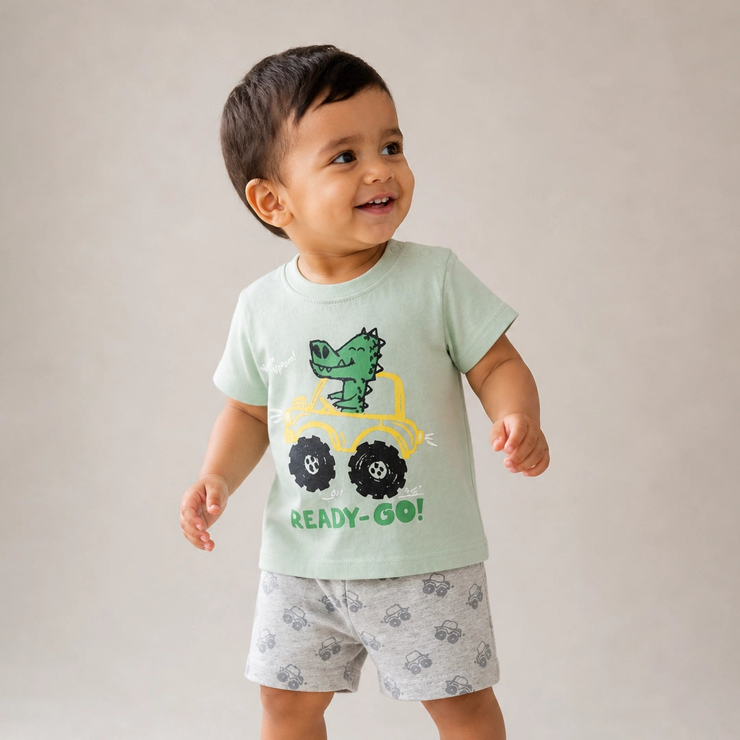 Child wearing a light green t-shirt with a dinosaur graphic and 'READY-Go!' text, standing against a plain background.